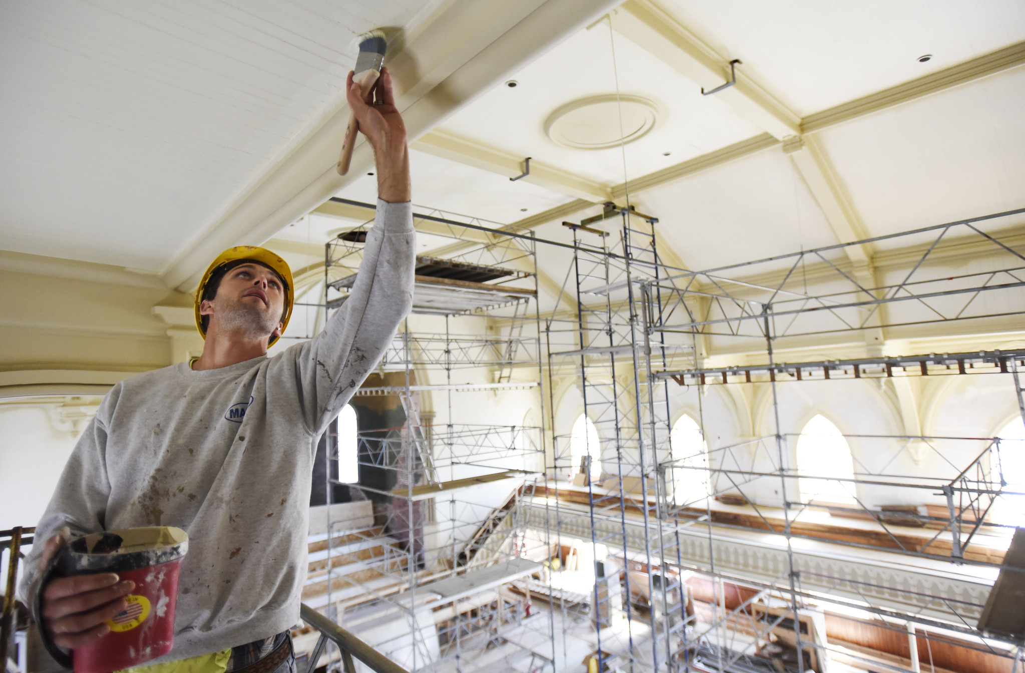 A construction worker touches up pain on the ceiling in the great hall at UPH in Saratoga Tuesday, June 4, 2019.