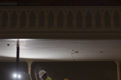 A construction worker is lit by worklight as sun streams through stained glass in the balcony of the great hall during construction at UPH Monday, Novermber 11, 2019. Photo credit: Kate Penn - Proctors