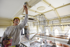 A construction worker touches up pain on the ceiling in the great hall at UPH in Saratoga Tuesday, June 4, 2019.